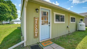 A green building with a blue door, a welcome sign, and a propane tank. - Fire Pit, Private Dock! Lamoka Lake Retreat (Bradford)