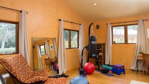 A room with a large window, a punching bag, exercise balls, and a chair. - Mi Casa - Monterey Home - Del Monte Golf Course Frontage (Monterey)