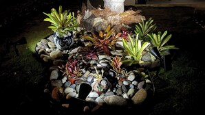 A garden with a stone sculpture, various plants, and a stone pathway. - Oceanpointe Serenity Get Away-solar Pool Wifi (Lucea)