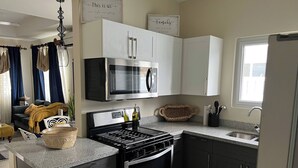 A modern kitchen with a stove, oven, microwave, and cabinets. - Oceanpointe Serenity Get Away-solar Pool Wifi (Lucea)