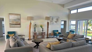 A modern living room with grey sofas, a coffee table, and floor lamps. - Oceanpointe Serenity Get Away-solar Pool Wifi (Lucea)