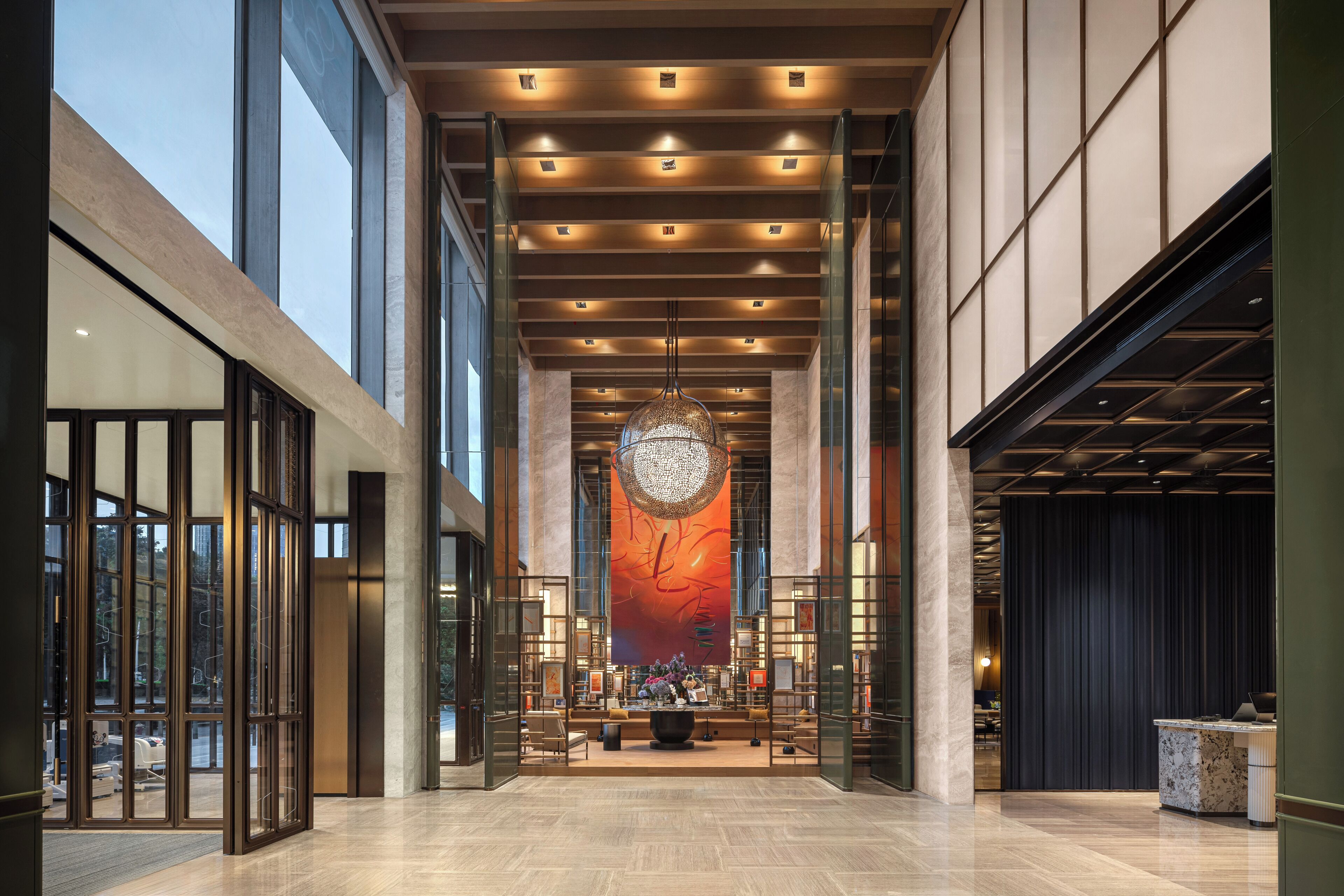 Un hall d’entrée spacieux, doté d’un plafond haut, d’un éclairage moderne et d’une pièce décorative centrale.