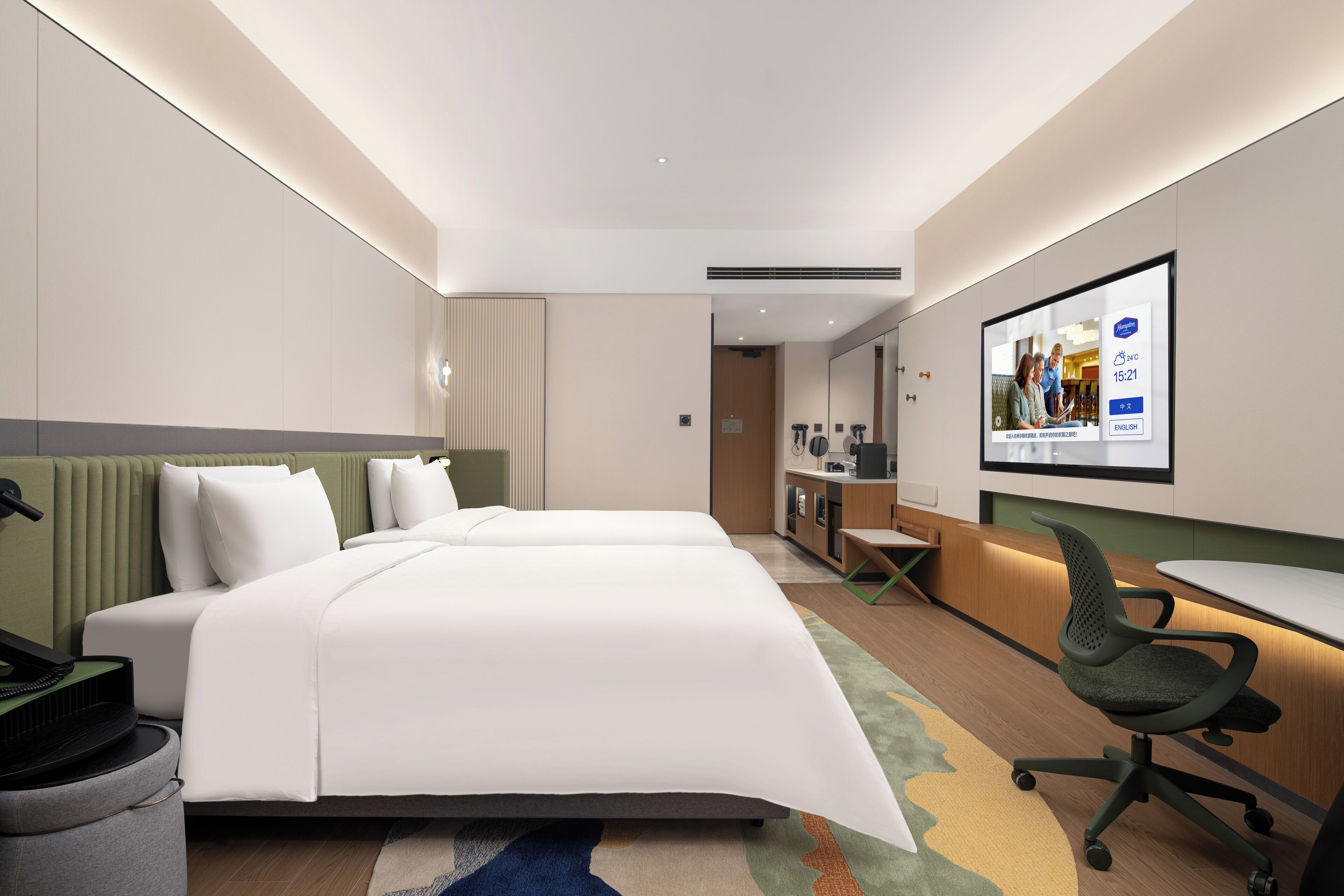 Une chambre d’hôtel moderne dotée d’un grand lit, d’un bureau et d’un coin salon.