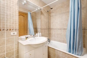 A bathroom with a sink, mirror, shower, and tiled walls. - Charming 2-Bedroom Apartment in Playa San Juan, Spain (Guía de Isora)