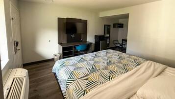 Een slaapkamer met een bed, een bureau, een stoel en een verwarming.