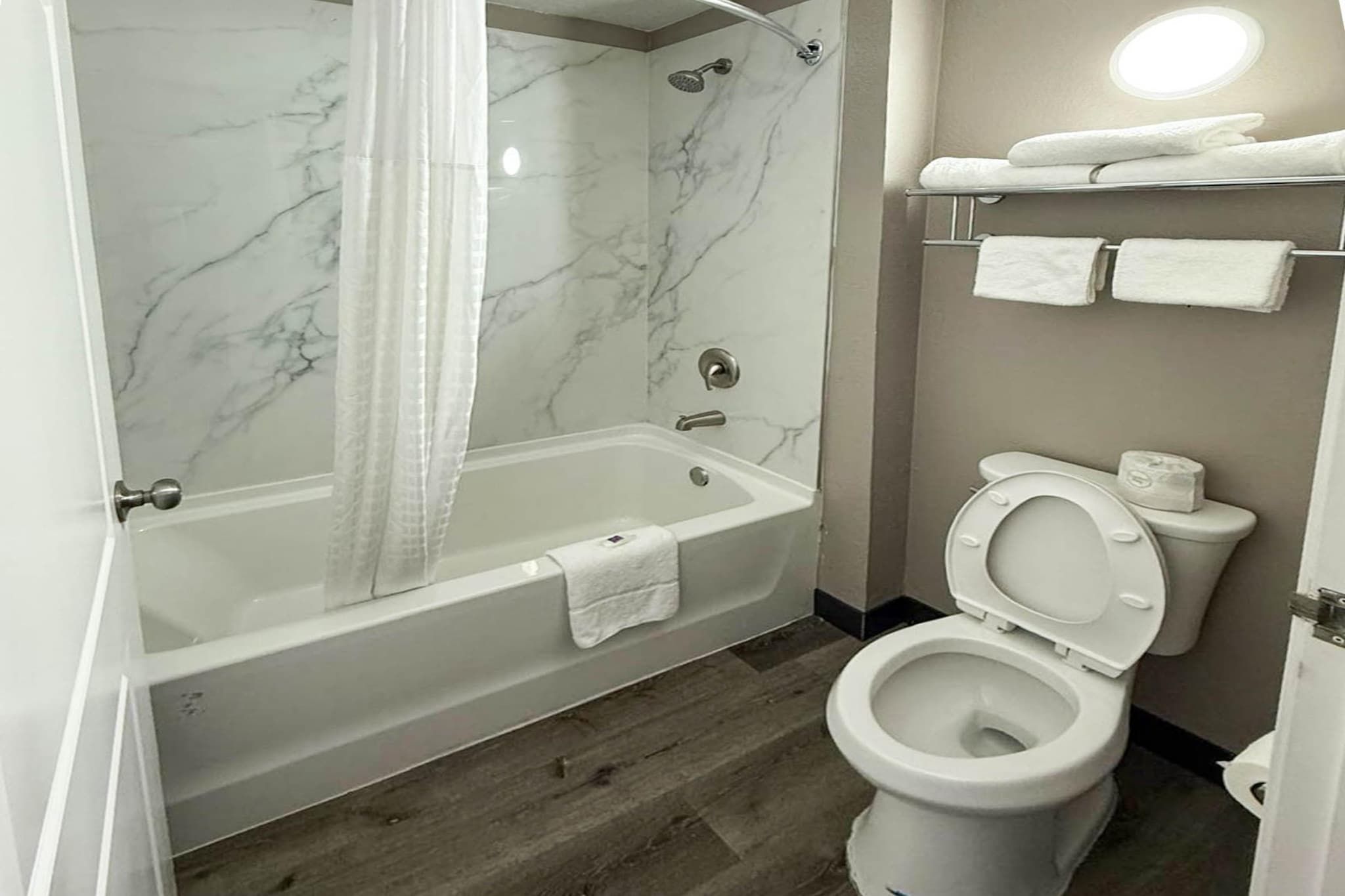 A bathroom with a bathtub, toilet, and a shower area.