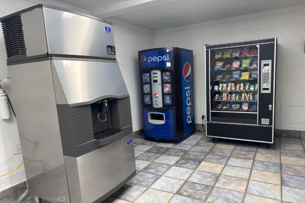 Un distributeur automatique, un réfrigérateur et un appareil à eau dans un espace commercial.