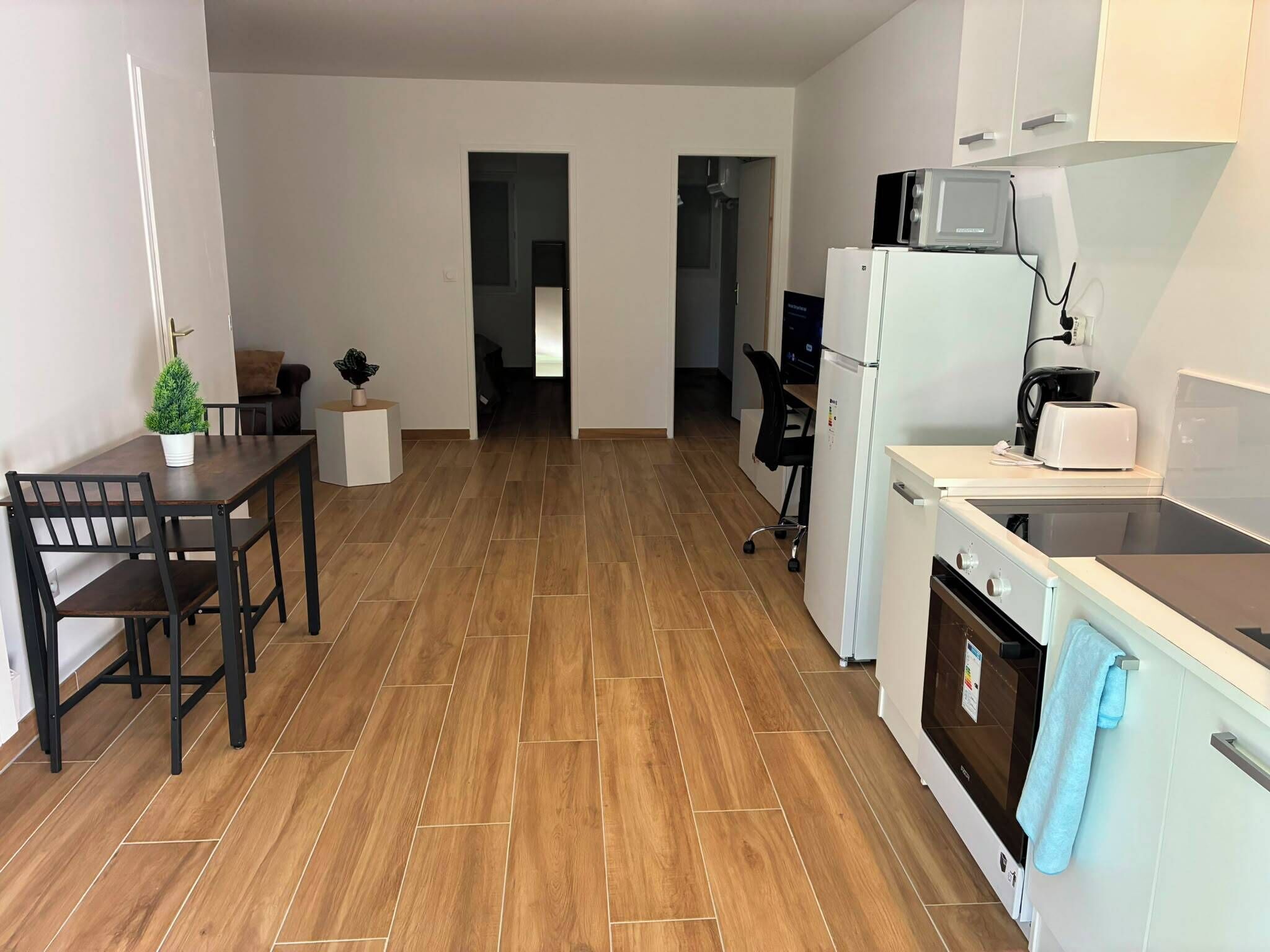 A kitchen with a dining area, a microwave, a toaster, an oven, and a sink.