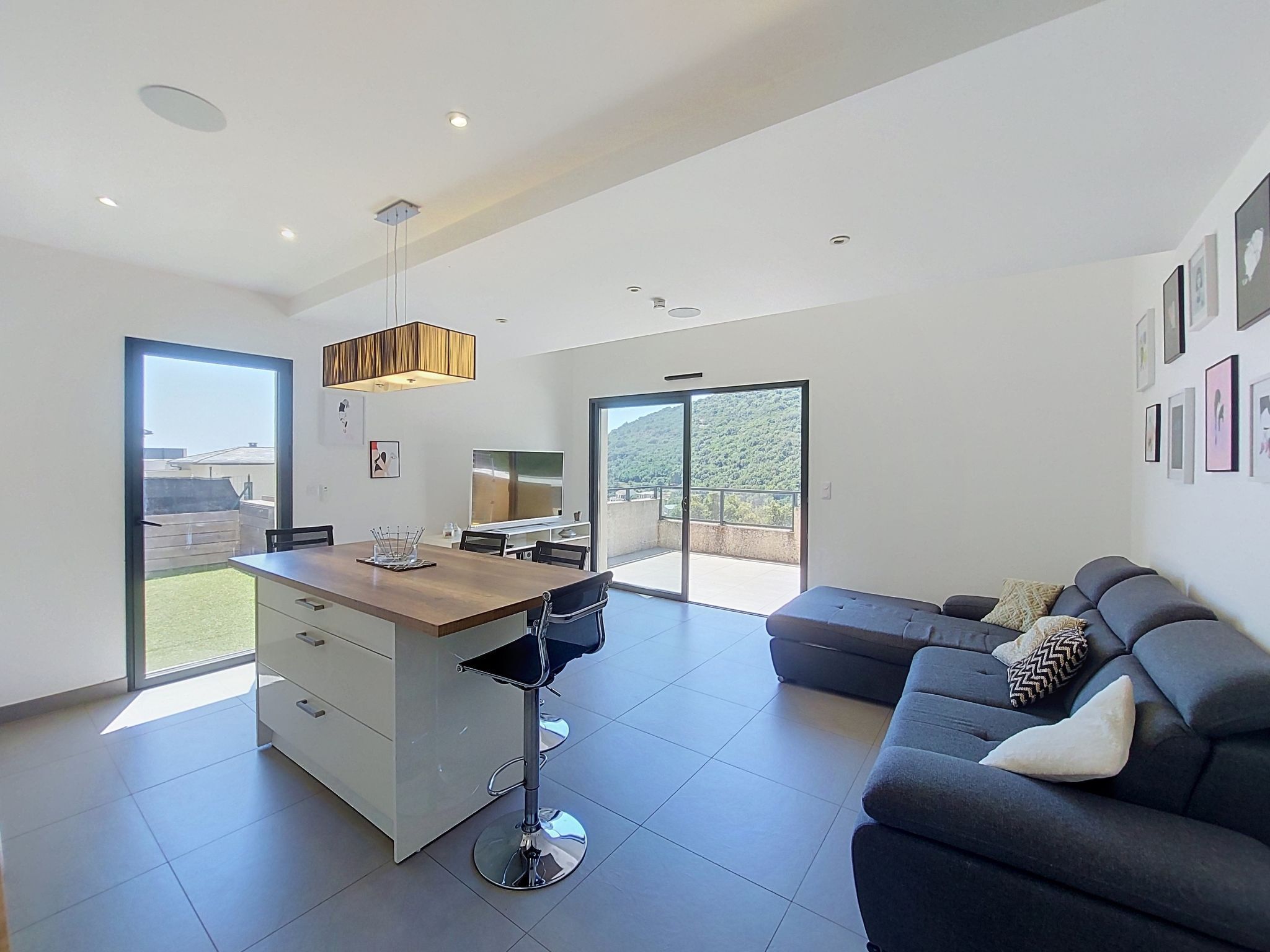 Un espacio habitable moderno con cocina, comedor y sofá.