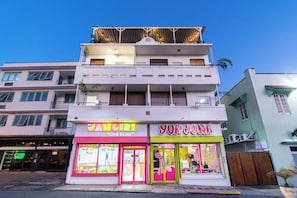 Een meerlaags gebouw met een restaurant genaamd 'Yum Junk' op de begane grond en een zaak genaamd 'Poke Bowls' op de tweede verdieping.