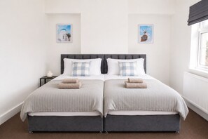 A double bed with two pillows, a bedside table with a lamp, and two framed pictures on the wall. - Blyth 4BR House | Sleeps 8 | WiFi | Crew Stay (Blyth)