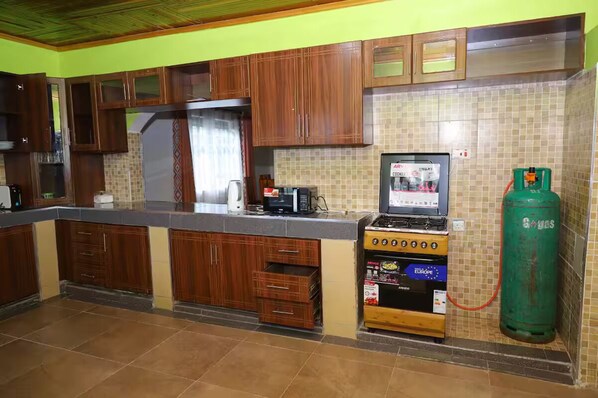A kitchen with wooden cabinets, a gas stove, and a tiled backsplash.