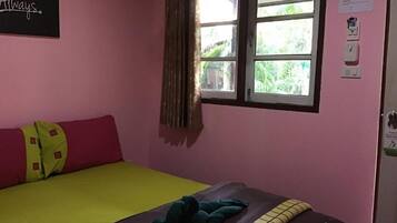 Una habitación con cama, una ventana con cortinas, un letrero en la pared y una puerta con interruptor de luz.