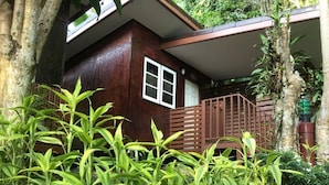 A wooden house with a window and a staircase leading to a porch. - Grand Tree Resort (Ko Chang)