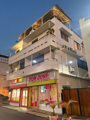 Ein mehrstöckiges Gebäude mit einem Restaurant namens 'Yum Junk' im Erdgeschoss.