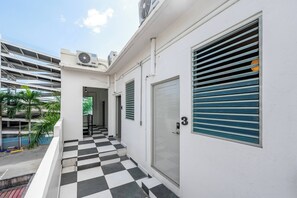A building with a checkered floor, a door marked with the number 3, and air conditioning units on the roof. - Barrio Sanctuary - Luna (San Juan city)