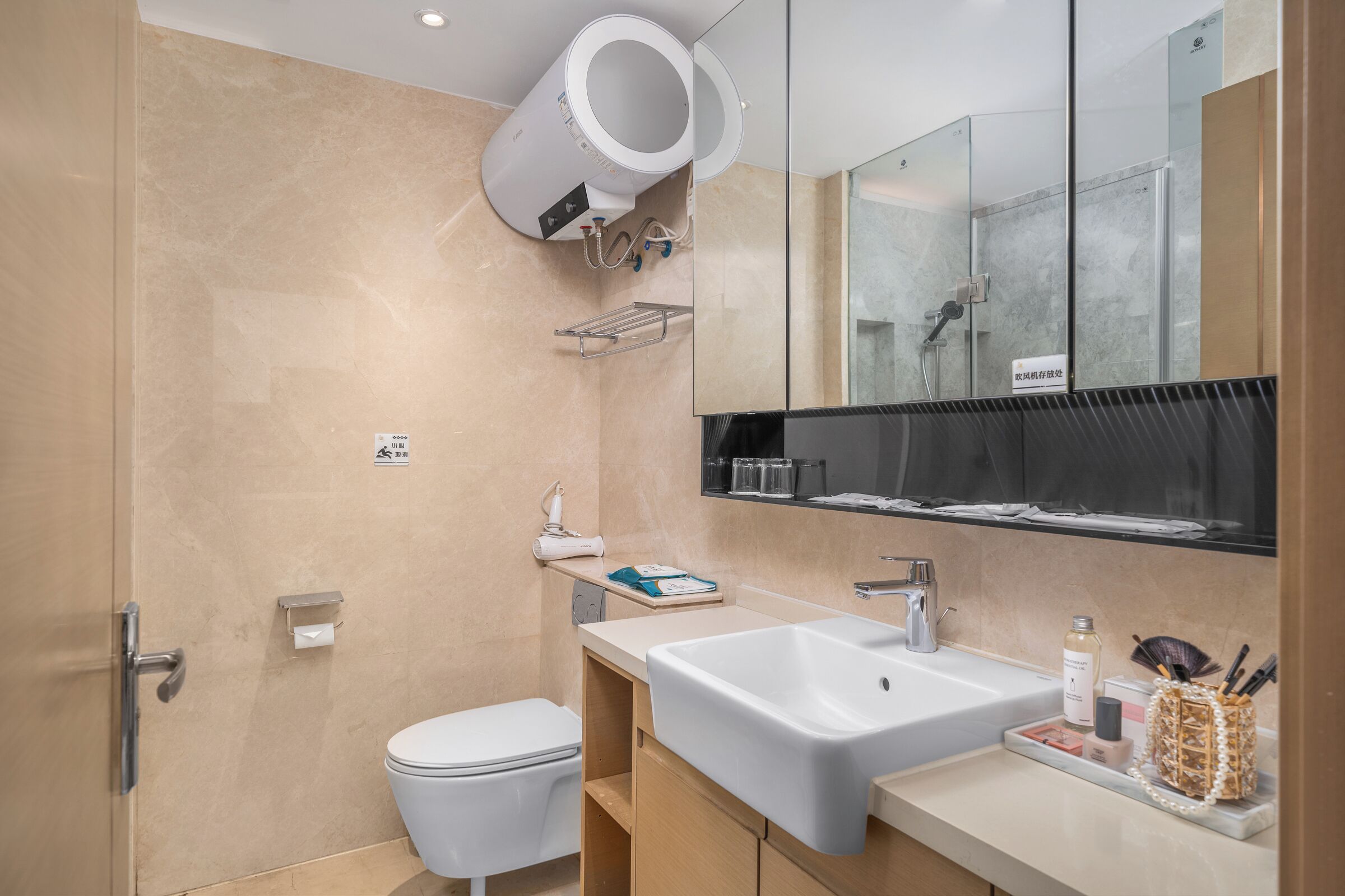A modern bathroom with a toilet, sink, mirror, and shower.