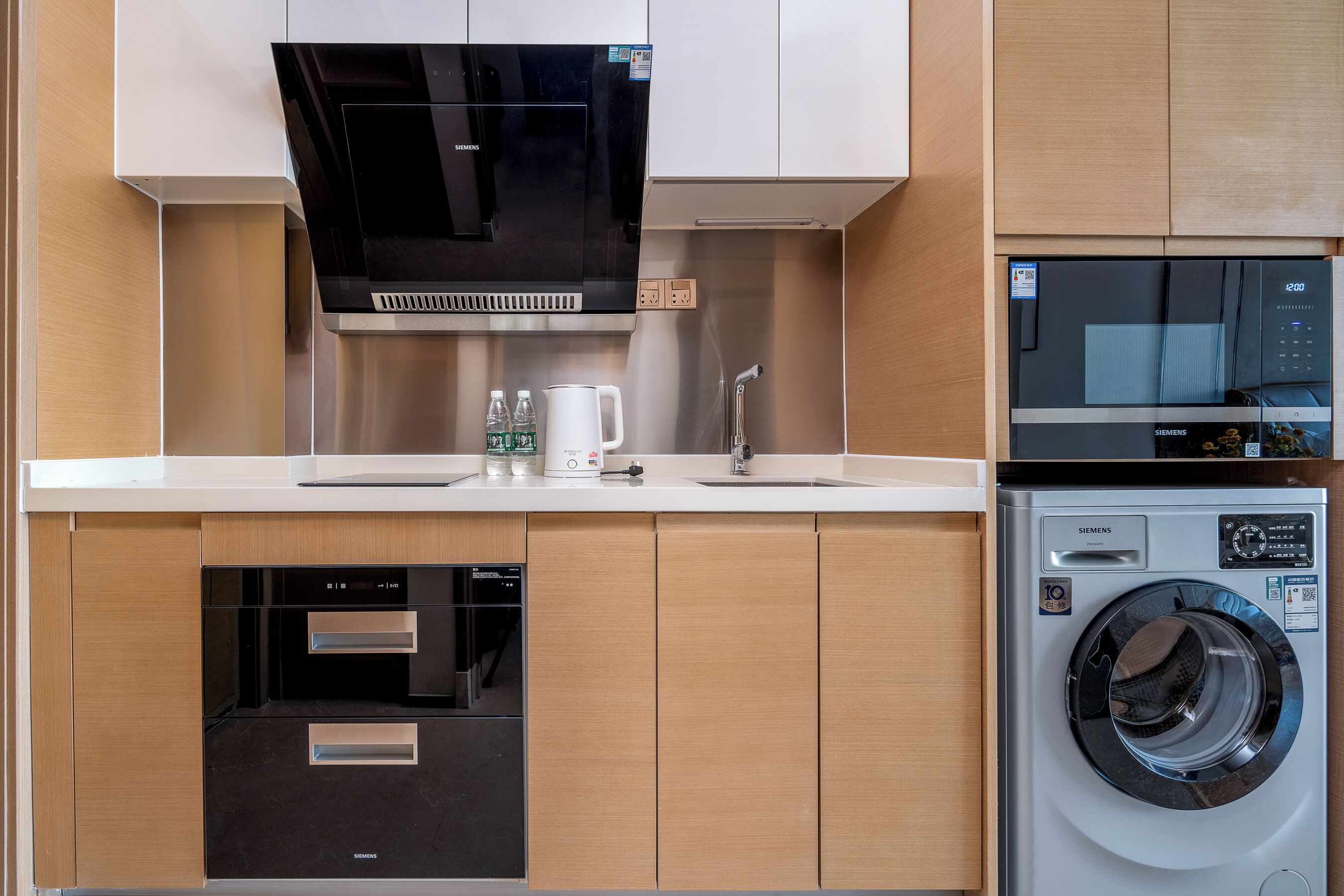 Une cuisine moderne dotée d’appareils électroménagers intégrés, notamment un lave-vaisselle, un four et un lave-linge.