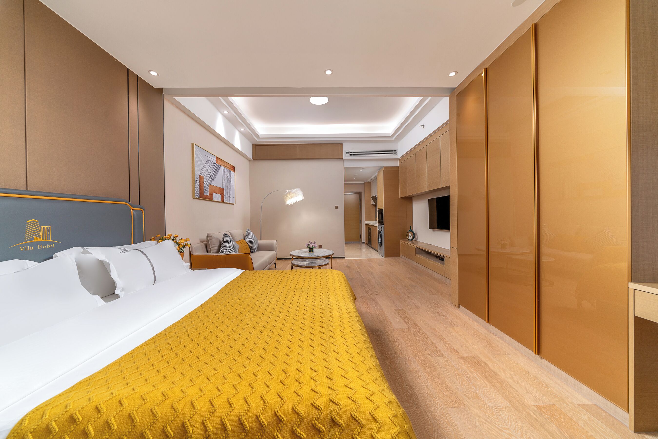 Une chambre d’hôtel équipée d’un lit, d’un canapé, d’une télévision et d’une kitchenette.