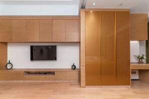 Un intérieur moderne avec un téléviseur à écran plat fixé au mur, des meubles en bois et une porte coulissante.