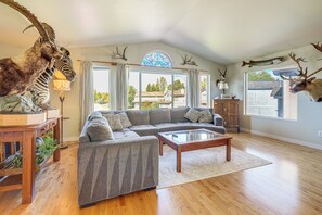 A living room with a sectional sofa, a coffee table, and a large window with curtains. - 3 Mi to Alaska Zoo! Anchorage Adventure Basecamp (Anchorage)