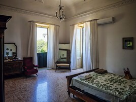 Un dormitorio con cama, una silla, un escritorio y un aparador.