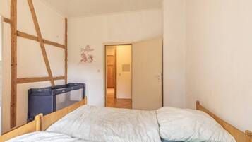 Un dormitorio con cama, armario y puerta que da a otra habitación.