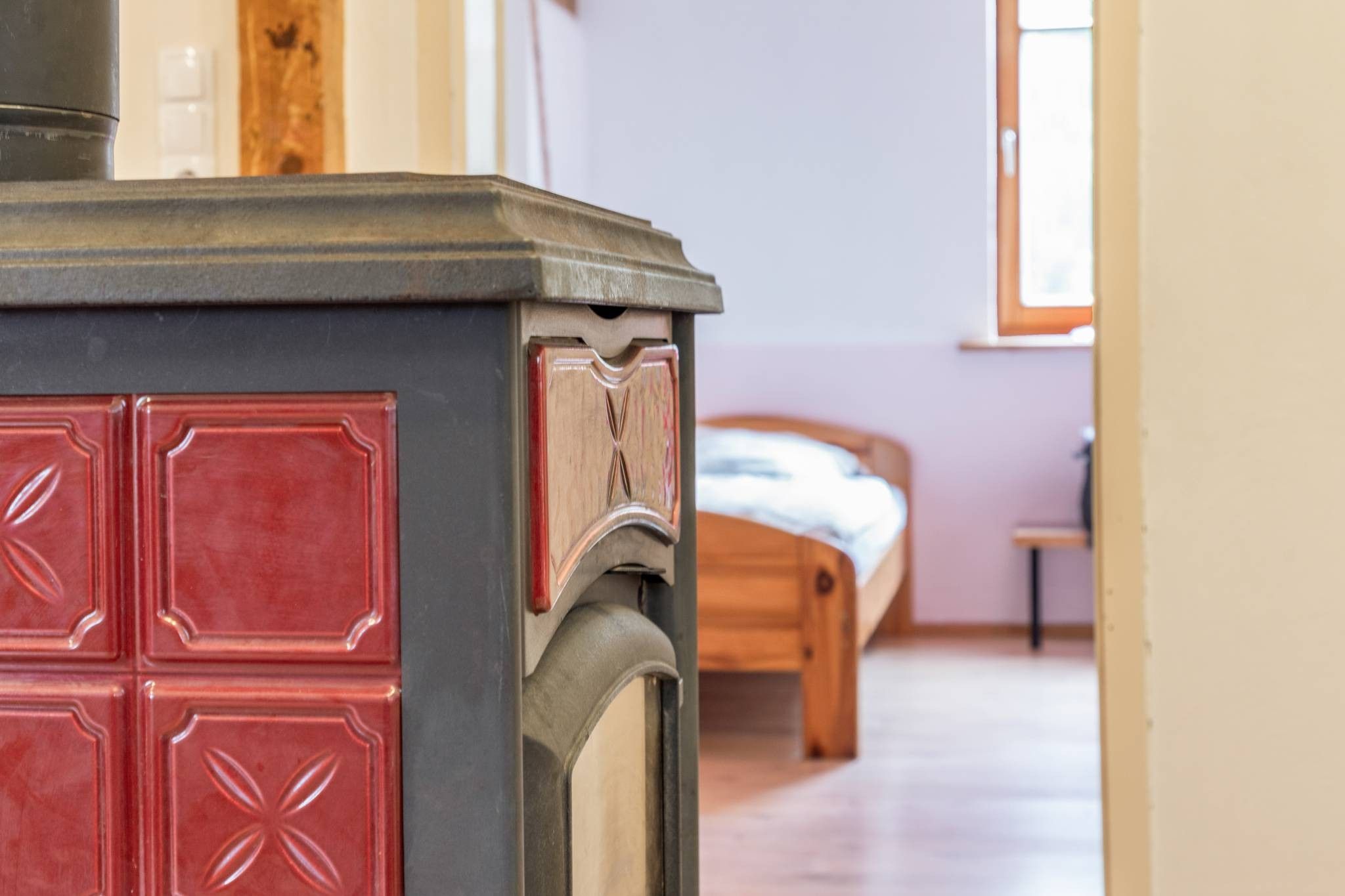 A room with a bed, a wooden dresser, and a window.