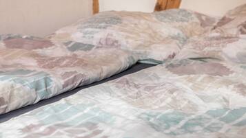 A bed with a patterned bedspread and pillows.