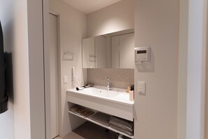 A modern bathroom with a white sink, a mirror, and a towel rack. - Giraffe Nakasu haku (Fukuoka)