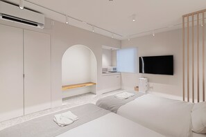 A modern hotel room with a bed, a TV, a kitchenette, and a bathroom. - Giraffe Nakasu haku (Fukuoka)