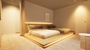 A modern bedroom with a large bed, a bedside table, and a small round table. - Giraffe Nakasu haku (Fukuoka)