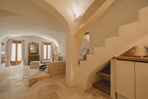A spacious interior with a high ceiling, a staircase, and a kitchen area. - Elite Collection - Olea: The Secret Roof (Olbia)
