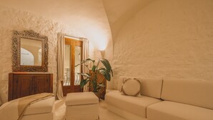 Ein gemütliches Wohnzimmer mit einer Couch, einem Hocker und einem Kamin.