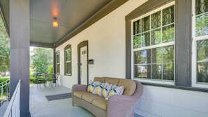 A covered porch with a wicker sofa, a dining table, and chairs. - Family-Friendly Retreat w/ Fireplaces in Greenwood (Greenwood)