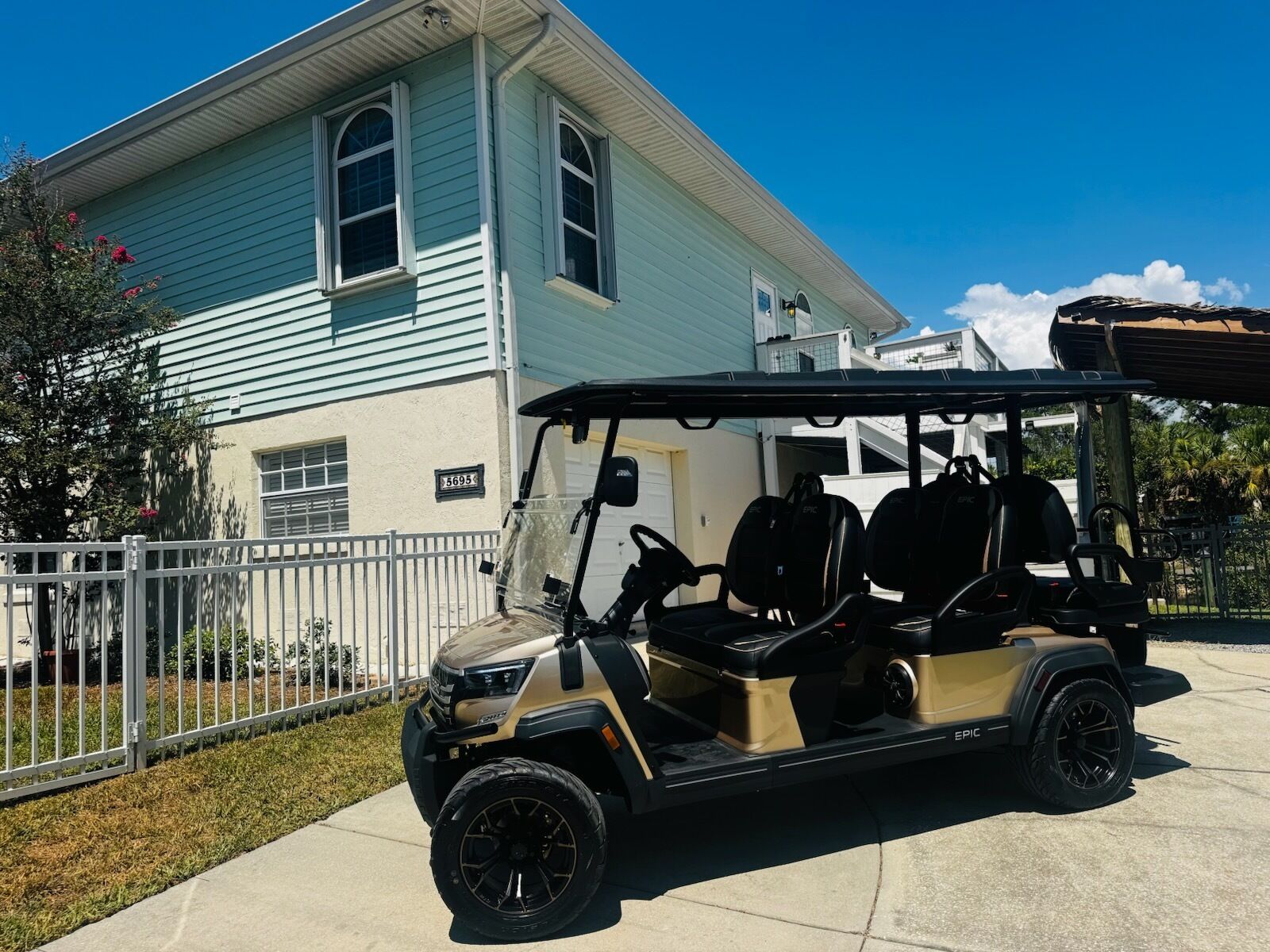 Un carrito de golf estacionado frente a una casa con garaje.
