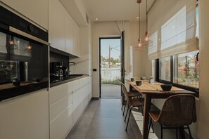 Una cocina moderna con comedor, ventanas amplias y vistas al exterior.