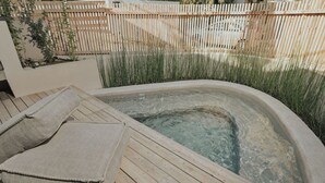 A hot tub with a wooden deck and cushions. - Elsa Modern Apartments (Pogonia)