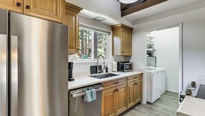 Una cocina moderna con electrodomésticos de acero inoxidable, armarios de madera y lavavajillas integrado.
