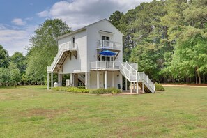 A two-story house with a balcony, a staircase, and a covered porch area. - Pool, Dock + Rooftop Views! Bohannon Getaway (Bohannon)