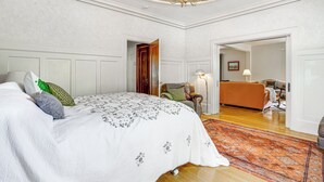 Un dormitorio con una cama grande, una silla, un sofá y una alfombra.
