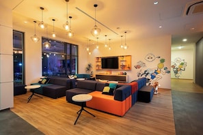 Ein modernes Wohnzimmer mit einem Ecksofa, einem runden Couchtisch und Pendelleuchten.