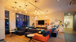 Een moderne woonkamer met een hoekbank, een rond salontafeltje en hanglampen.
