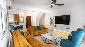 Ein modernes Wohnzimmer mit einer Couch, einem Couchtisch und einem Fernseher.
