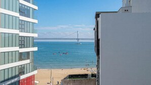 A view of a beach with a bridge in the background, a building with a balcony, and a clear sky. - Busan LaMer Gwangan Stay (Busan)