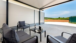 A modern outdoor seating area with a laptop on a table, a chair, and a sofa. - 2 bedroom awesome apartment in Rovinj (Rovinj)