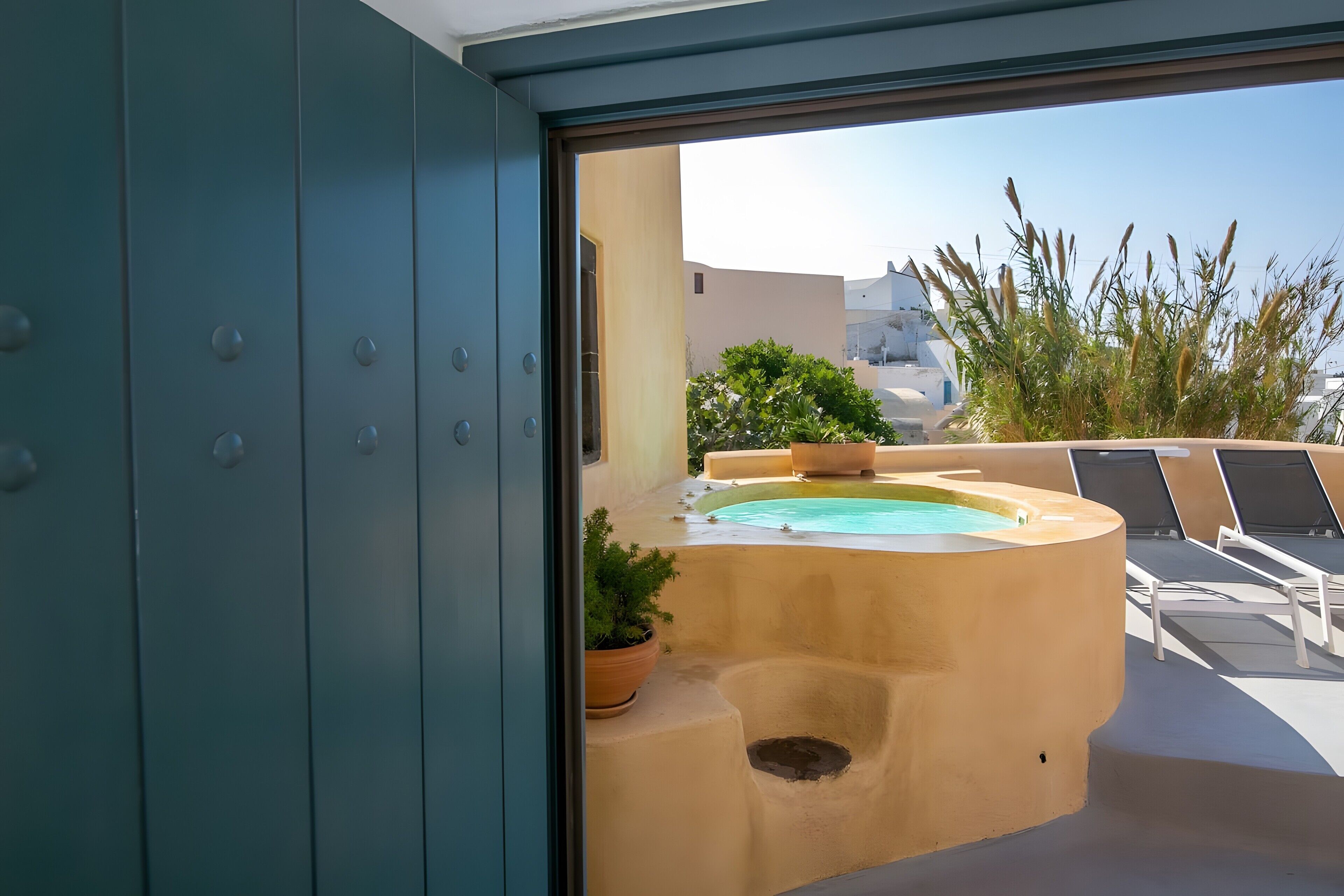 A pool area with lounge chairs and potted plants.