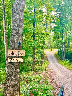 A forested area with a sign indicating a 'Stess-Free Zone' and a 'Respect Nature' sign on a tree. - Enchanted Woodland Retreat in Sparta, Tennessee (Sparta)
