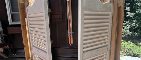 Une structure en bois dotée d’une porte en métal, d’un cadre de porte en bois et d’un portail en métal.
