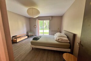 A bedroom with a bed, bench, chair, and a view of the outdoors. - Grand French Family Holiday Home (Saint-Germain sur Bresle)